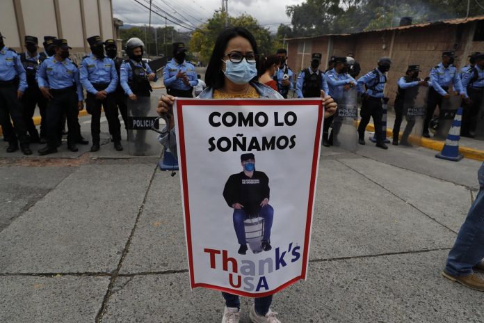 Una manifestante muestra un cartel contra el ex presidente de Honduras, Juan Orlando Hernández, acusado de narcotráfico.